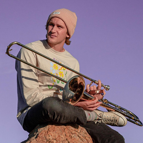 Kristoger with trombone on rock