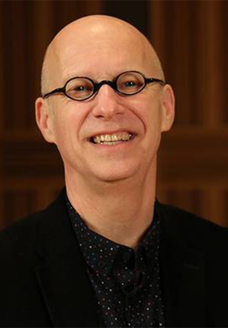 Headshot of William Cutter with a brown background