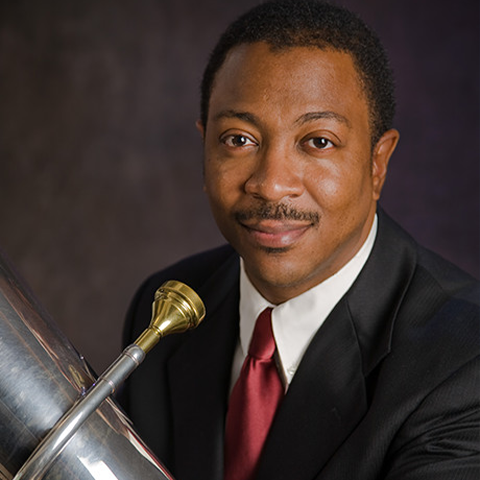 Kenneth Amis holding tuba and smiling