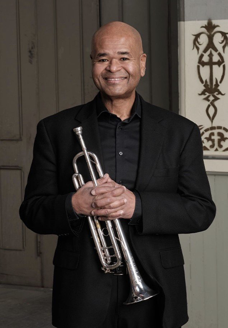 Richard Kelley in black suit posing with trumpet