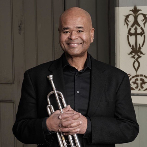 Richard Kelley in black suit posing with trumpet