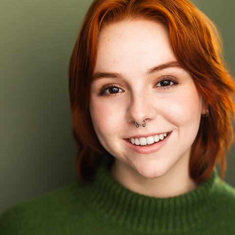 Ariella Berkman headshot: smiling in a green shirt in front of a green wall
