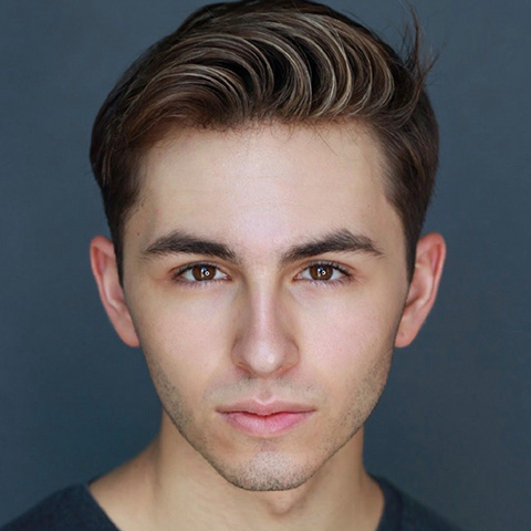 Logan Clancy headshot: in black shirt in front of dark blue wall