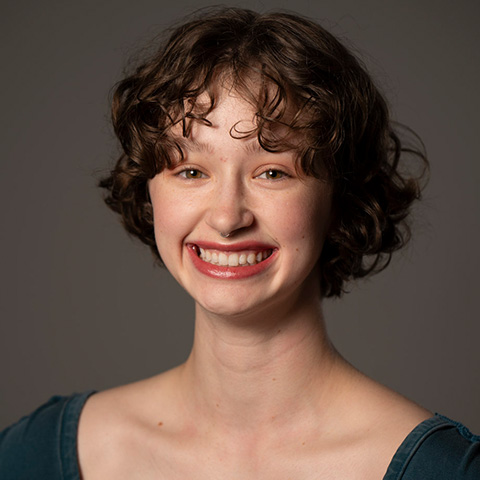 Dawvyn Winters headshot; smiling in a dark top