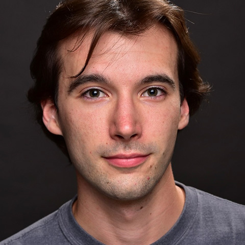 Willem Guenther headshot: in gray shirt in front of black wall
