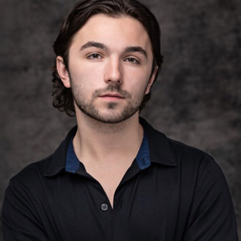 Jack Mullen Headshot: wearing black shirt in front of dar gray background