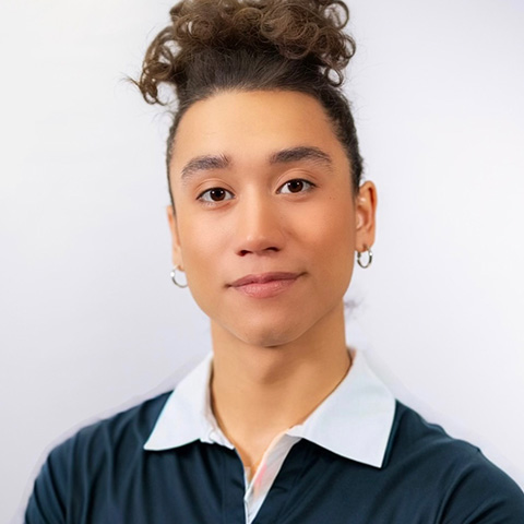 Nico Ochoa headshot: wearing black shirt with white collar in front of white background