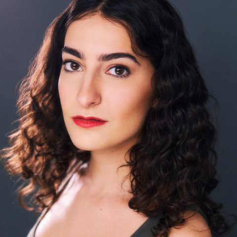 Nina Osso headshot: in front of dark navy background