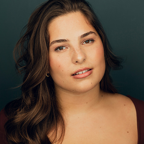 Isa Sanchez headshot: in front of dark blue background