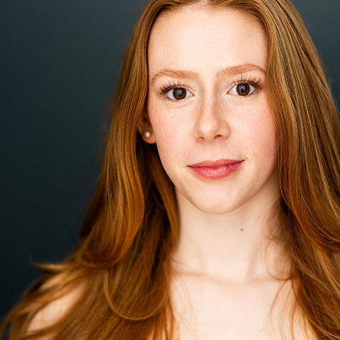 Jane Shearin headshot: in front of blue/black wall