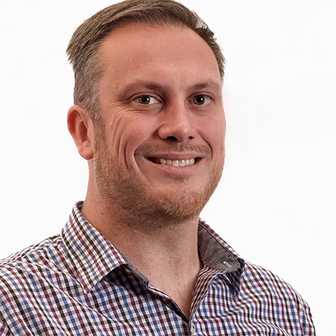Andy Crawford headshot. Andy is smiling in front of a white background in a dress shirt.