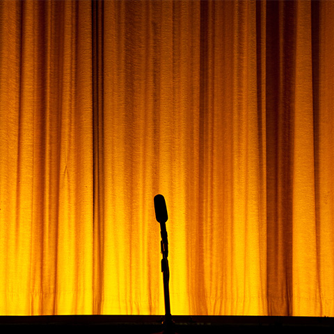 stage with yellow curtain and microphone