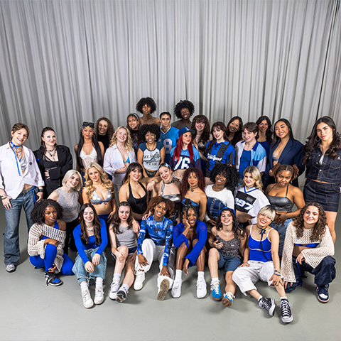 Commercial dance students group shot in a dance studio, wearing blue and white