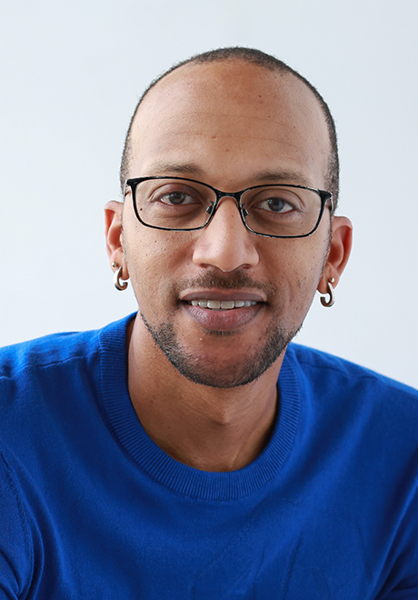 Kevin Haden headshot: smiling with glasses on in a blue shirt.