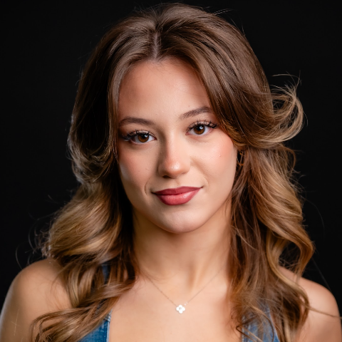 Julia Szostek headshot: smiling in front of a black background