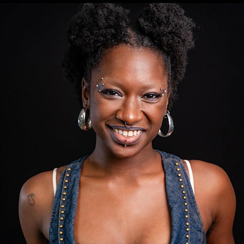 Mawell Pauls headshot: wearing a denim top in front of a black background