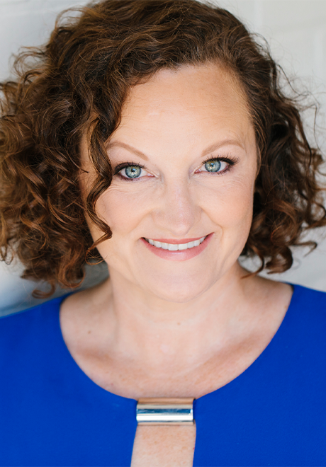Gina Beck headshot: smiling in a blue shirt