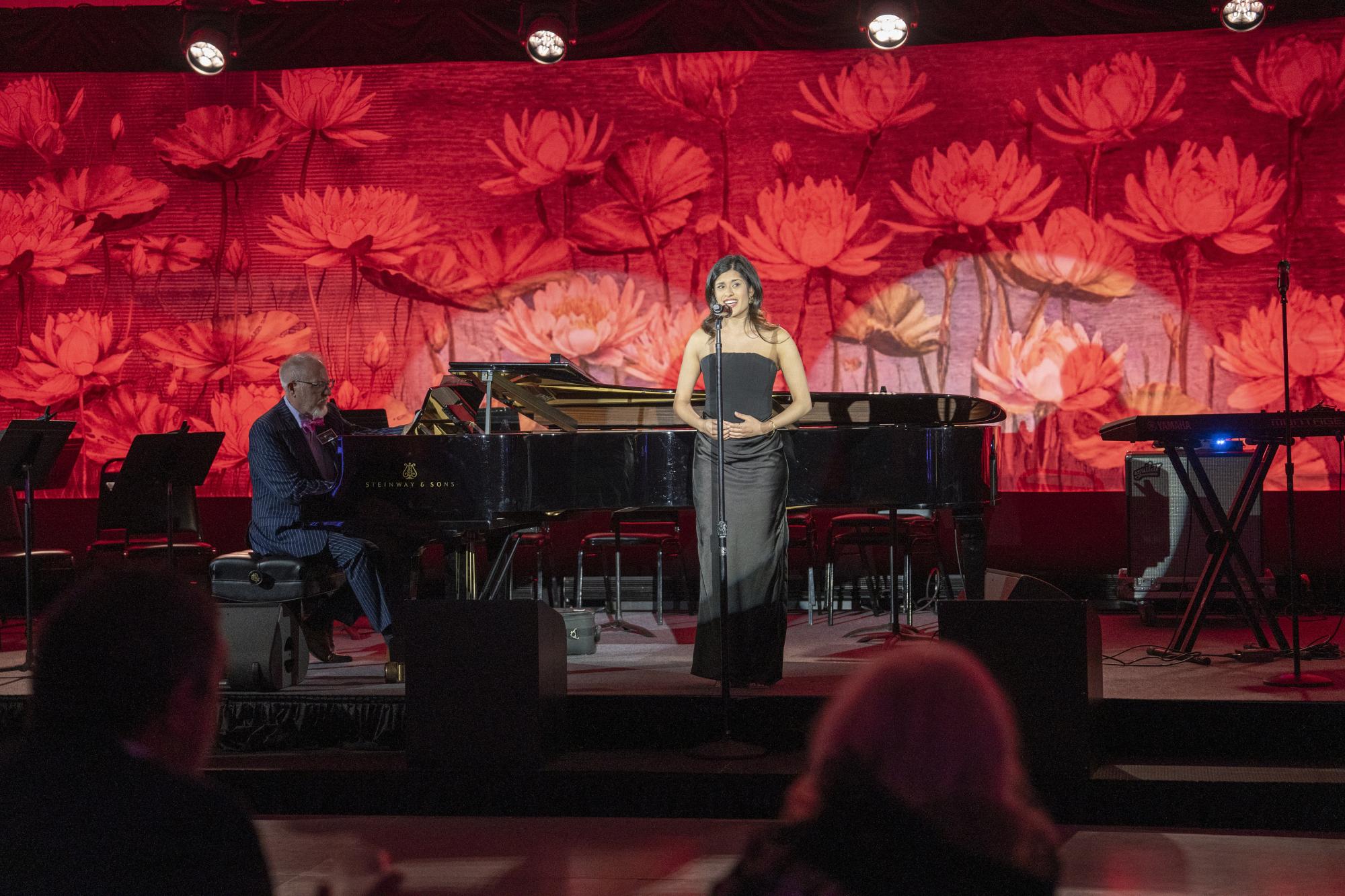 Student singing on stage in a black dress