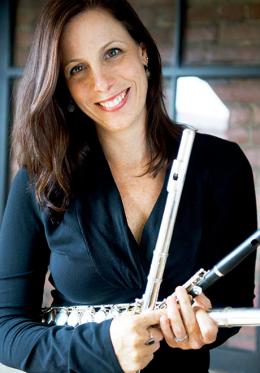 Sarah Brady smiles at the camera holding a piccolo