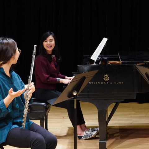 Flute player and pianist rehearsing together.