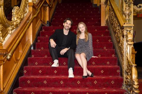 Michael Tacconi and Olivia Goosman sit on the ornate staircase at the Emerson Colonial Theatre.